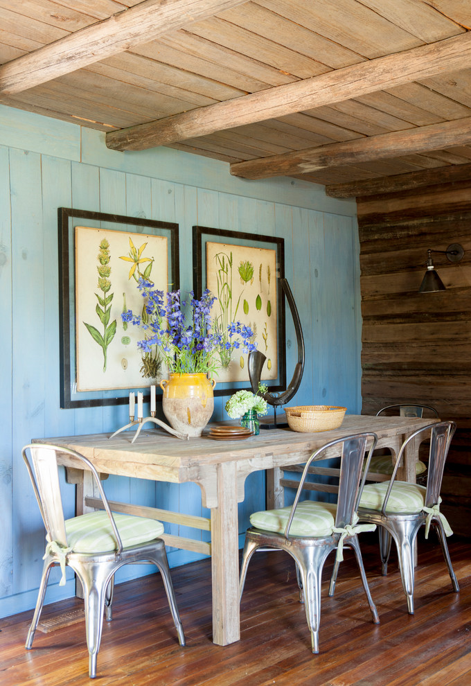 Immagine di una sala da pranzo country con pareti blu e pavimento in legno massello medio