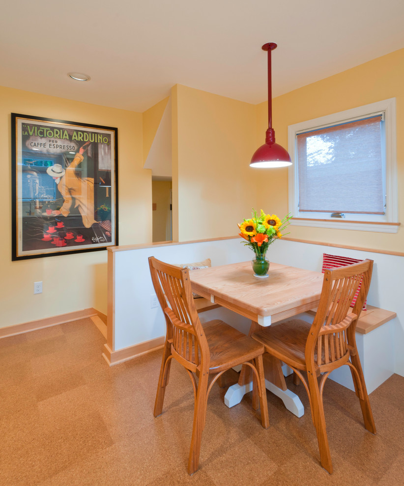 Immagine di una piccola sala da pranzo aperta verso la cucina classica con pareti gialle e pavimento in sughero