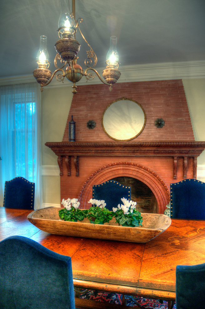 Immagine di una grande sala da pranzo tradizionale chiusa con pareti beige, parquet chiaro, camino classico, cornice del camino in mattoni e pavimento marrone