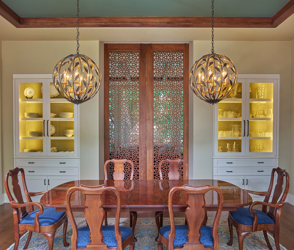 Immagine di una sala da pranzo mediterranea chiusa con pareti beige e pavimento in legno massello medio