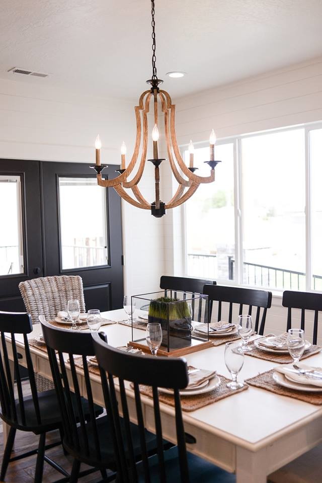 Cette photo montre une salle à manger ouverte sur la cuisine nature de taille moyenne avec un mur blanc, aucune cheminée, un sol marron et un sol en bois brun.