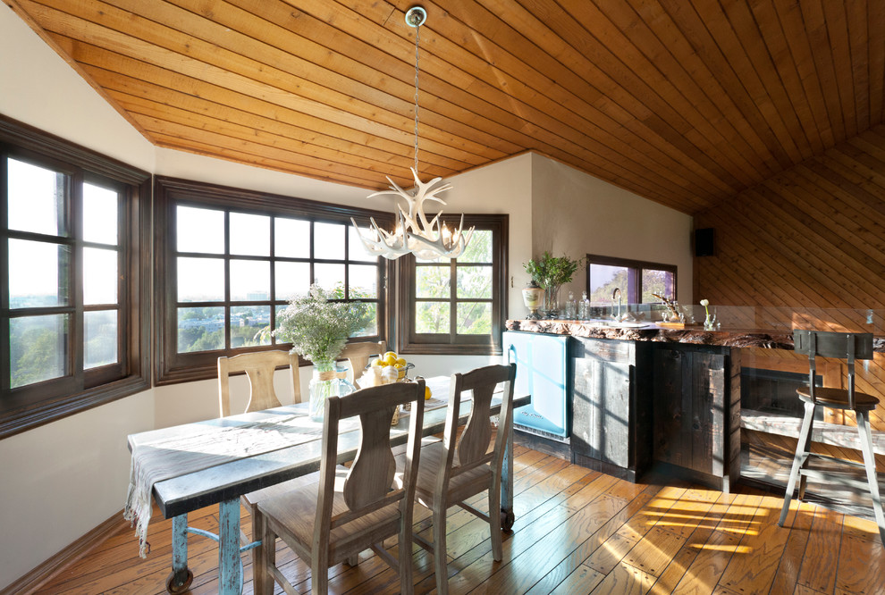 Immagine di una sala da pranzo stile rurale con pareti bianche e pavimento in legno massello medio