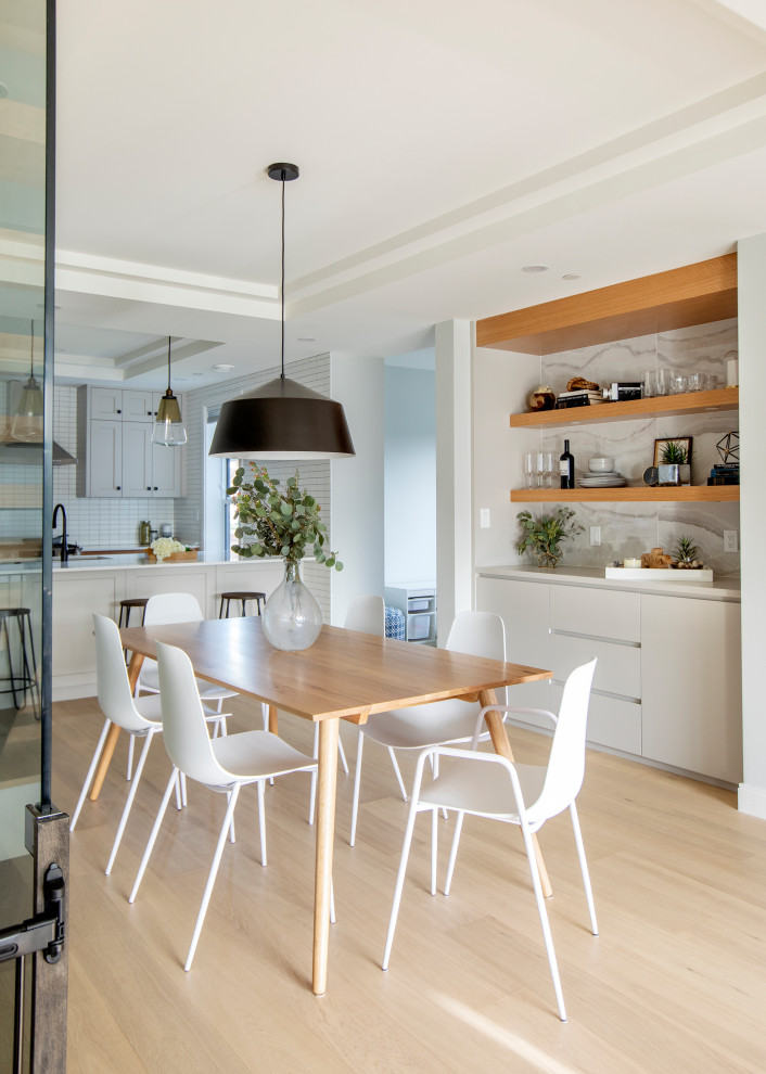 Example of a trendy light wood floor and beige floor kitchen/dining room combo design in Vancouver with white walls