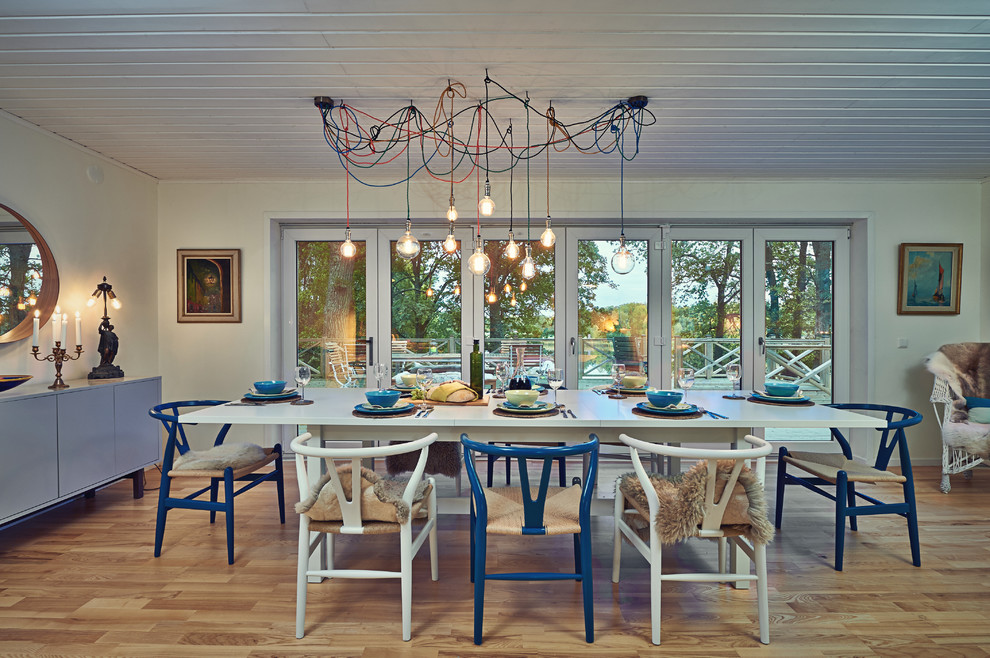 Inspiration pour une salle à manger ouverte sur le salon bohème avec un mur blanc, un sol en bois brun et un sol marron.