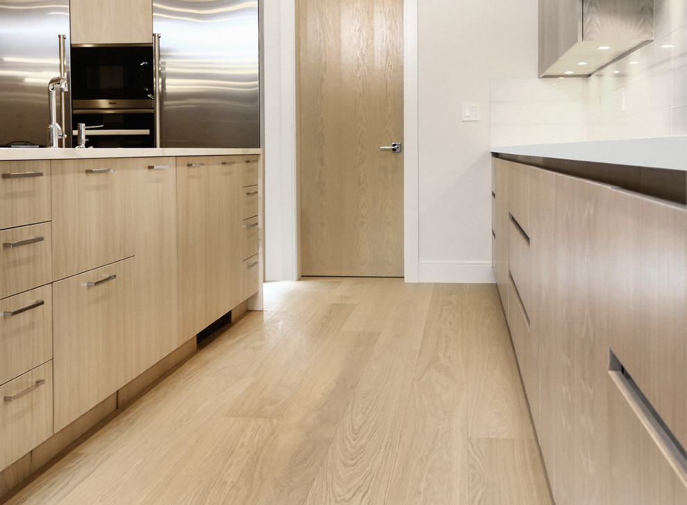Geräumige Moderne Wohnküche mit grauer Wandfarbe, hellem Holzboden und beigem Boden in Vancouver