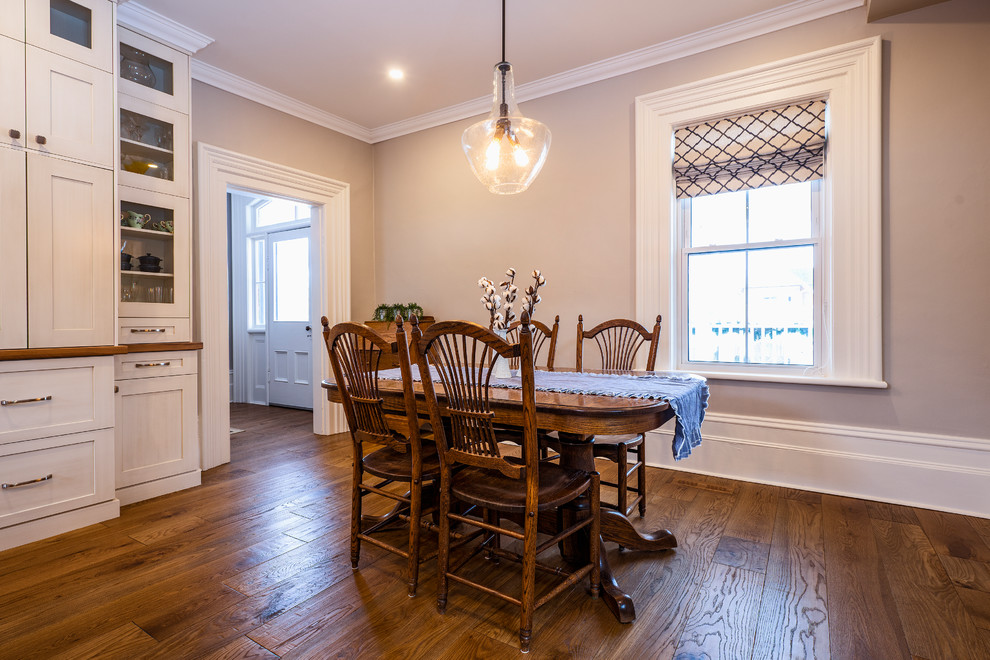 Idées déco pour une salle à manger ouverte sur la cuisine classique de taille moyenne avec un mur gris, un sol en bois brun et un sol marron.