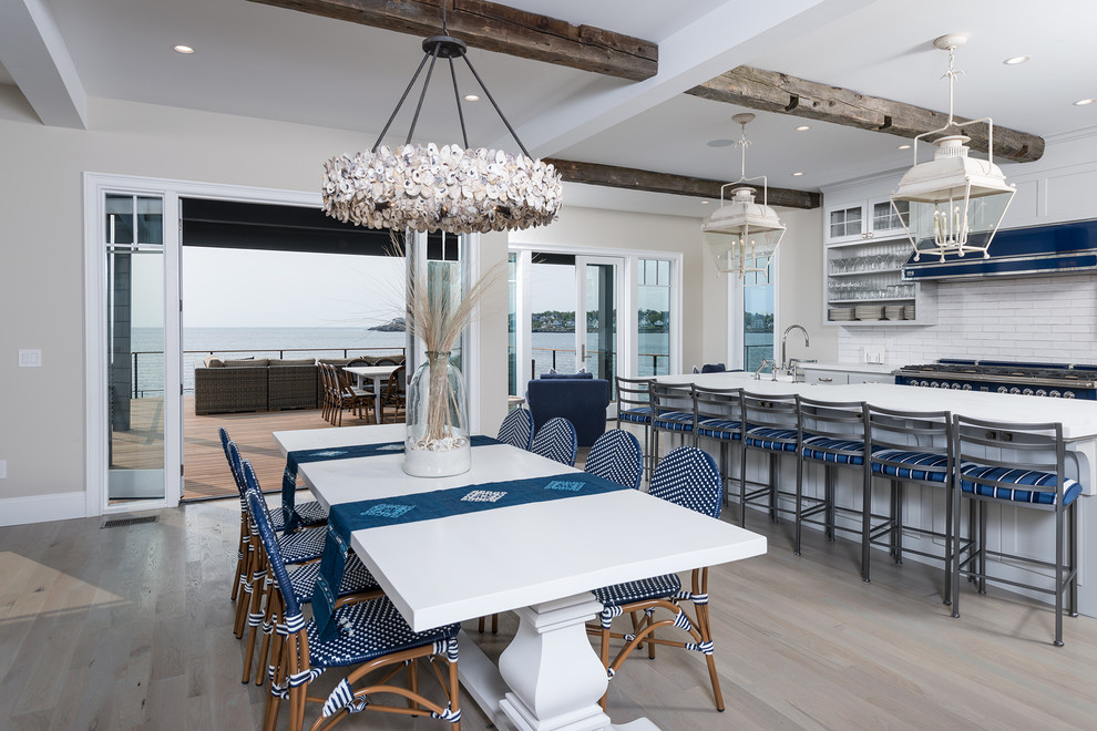 Esempio di una sala da pranzo aperta verso la cucina costiera con pareti beige, parquet chiaro e pavimento beige