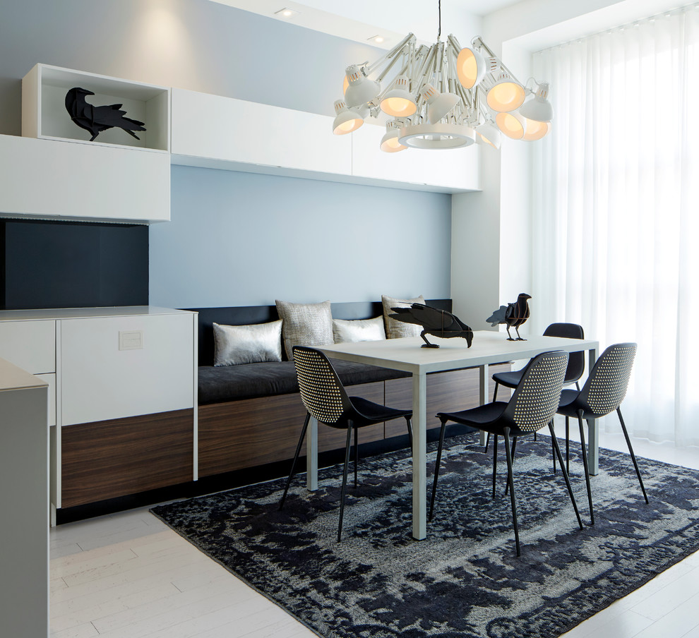 Ispirazione per una sala da pranzo minimal con pareti blu e pavimento in legno verniciato