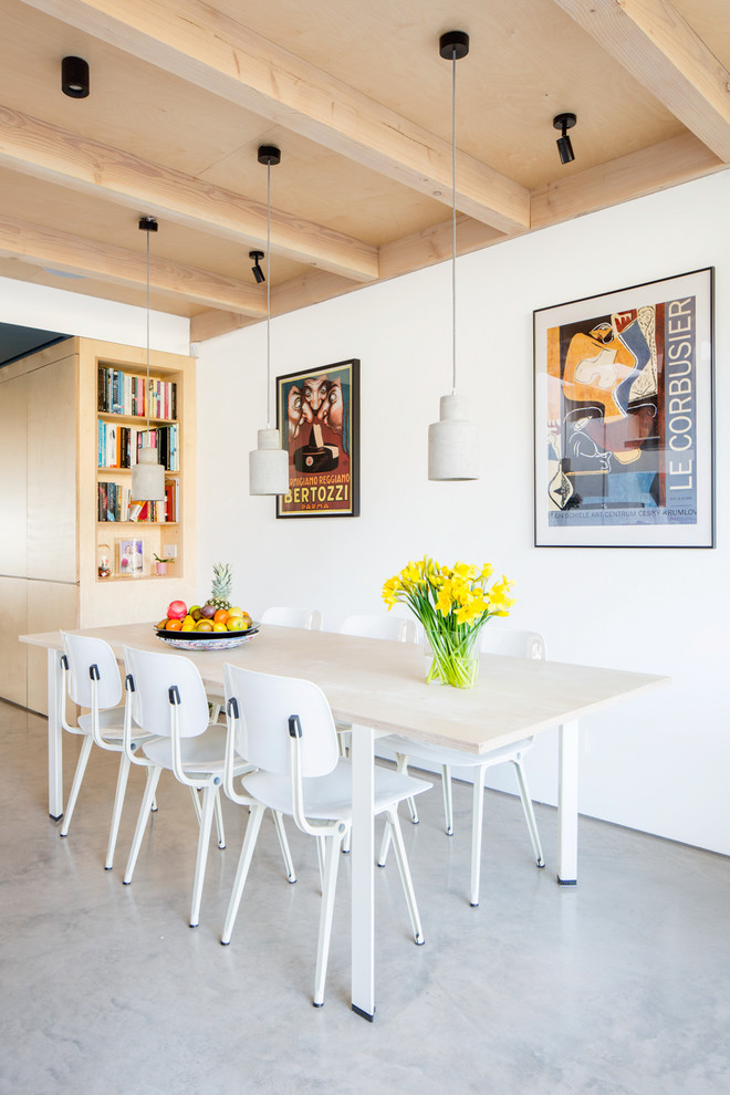Réalisation d'une salle à manger design avec un mur blanc, sol en béton ciré et un sol gris.