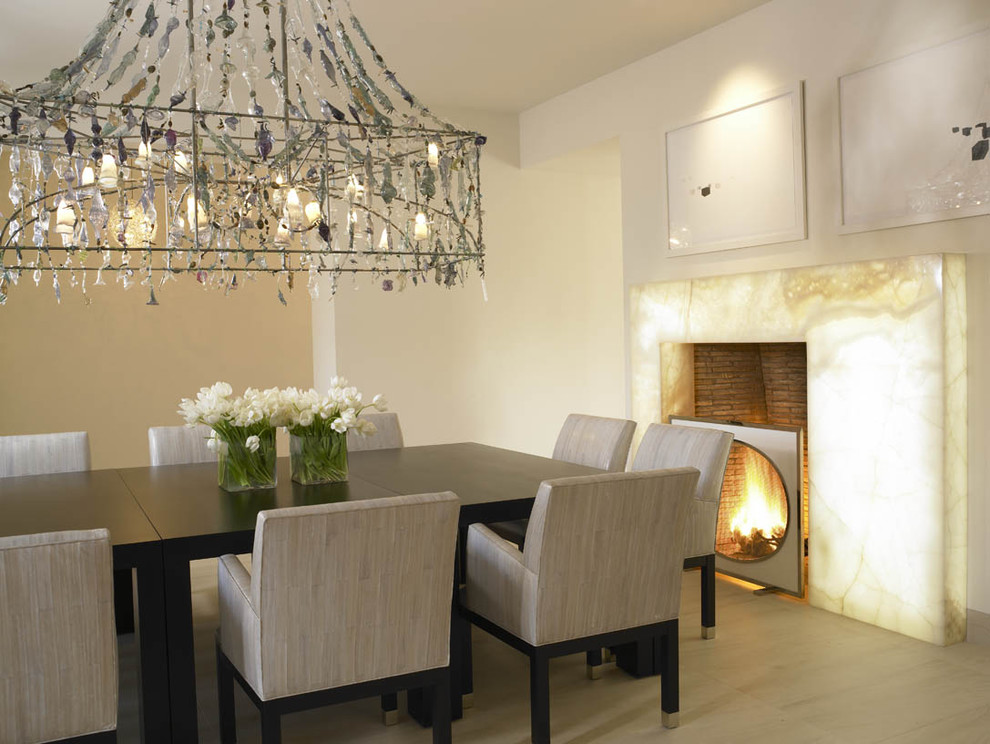 Photo of a mediterranean dining room in San Diego with beige walls and a standard fireplace.