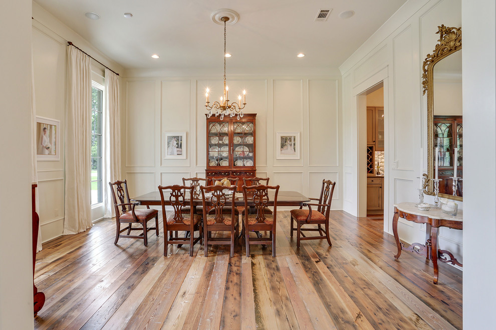 Cette photo montre une salle à manger chic avec un mur blanc, un sol en bois brun et aucune cheminée.