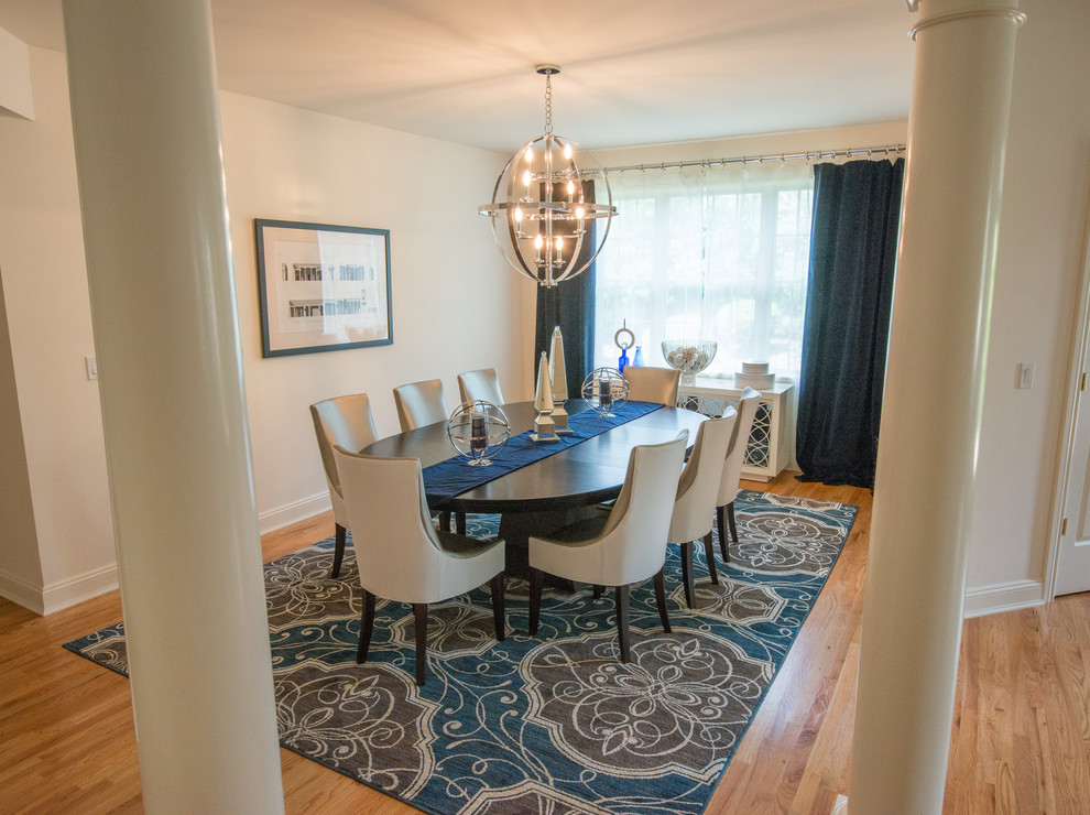 Photo of a traditional dining room in New York with white walls and medium hardwood flooring.