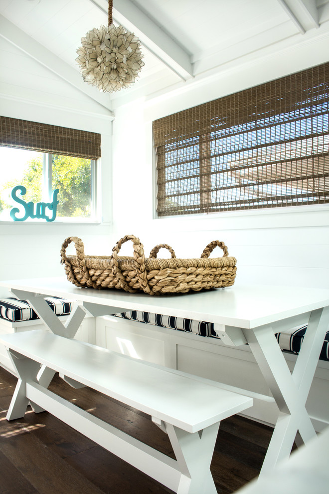Exemple d'une salle à manger bord de mer fermée et de taille moyenne avec un mur blanc, parquet foncé et un sol marron.