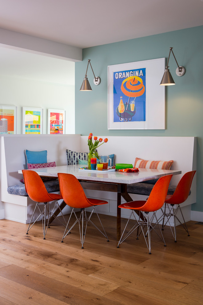 Réalisation d'une petite salle à manger ouverte sur la cuisine design avec un mur bleu, un sol en bois brun et un sol marron.