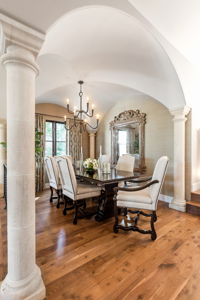 Foto di una grande sala da pranzo mediterranea chiusa con pareti beige, pavimento in legno massello medio, pavimento marrone e soffitto a volta