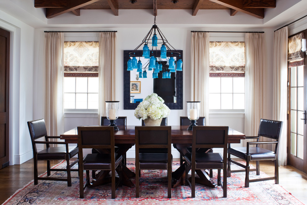 Coastal dining room in Los Angeles with white walls and dark hardwood flooring.