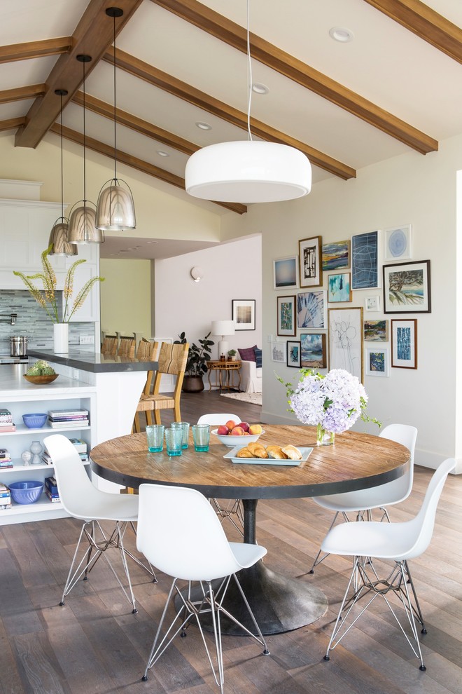 Aménagement d'une salle à manger ouverte sur la cuisine bord de mer avec un mur blanc, parquet foncé, aucune cheminée, un sol marron et éclairage.