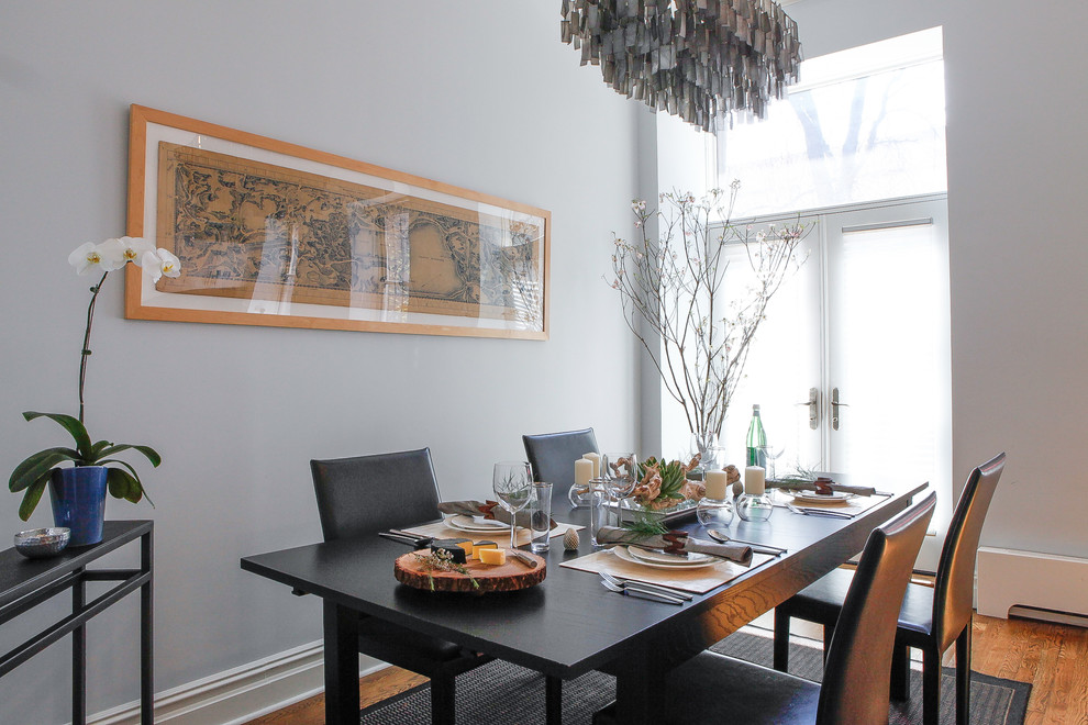 Idee per una sala da pranzo aperta verso la cucina chic di medie dimensioni con pareti grigie e parquet chiaro