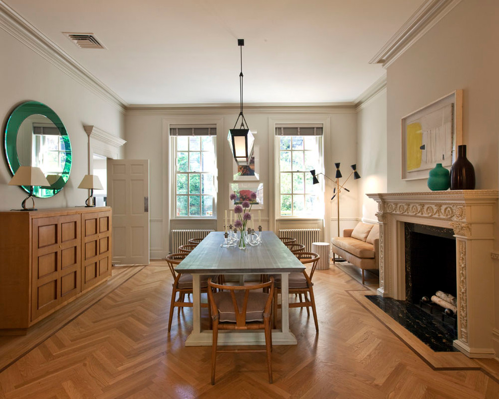 Aménagement d'une grande salle à manger moderne avec un mur blanc, un sol en bois brun, une cheminée standard, un manteau de cheminée en pierre et éclairage.