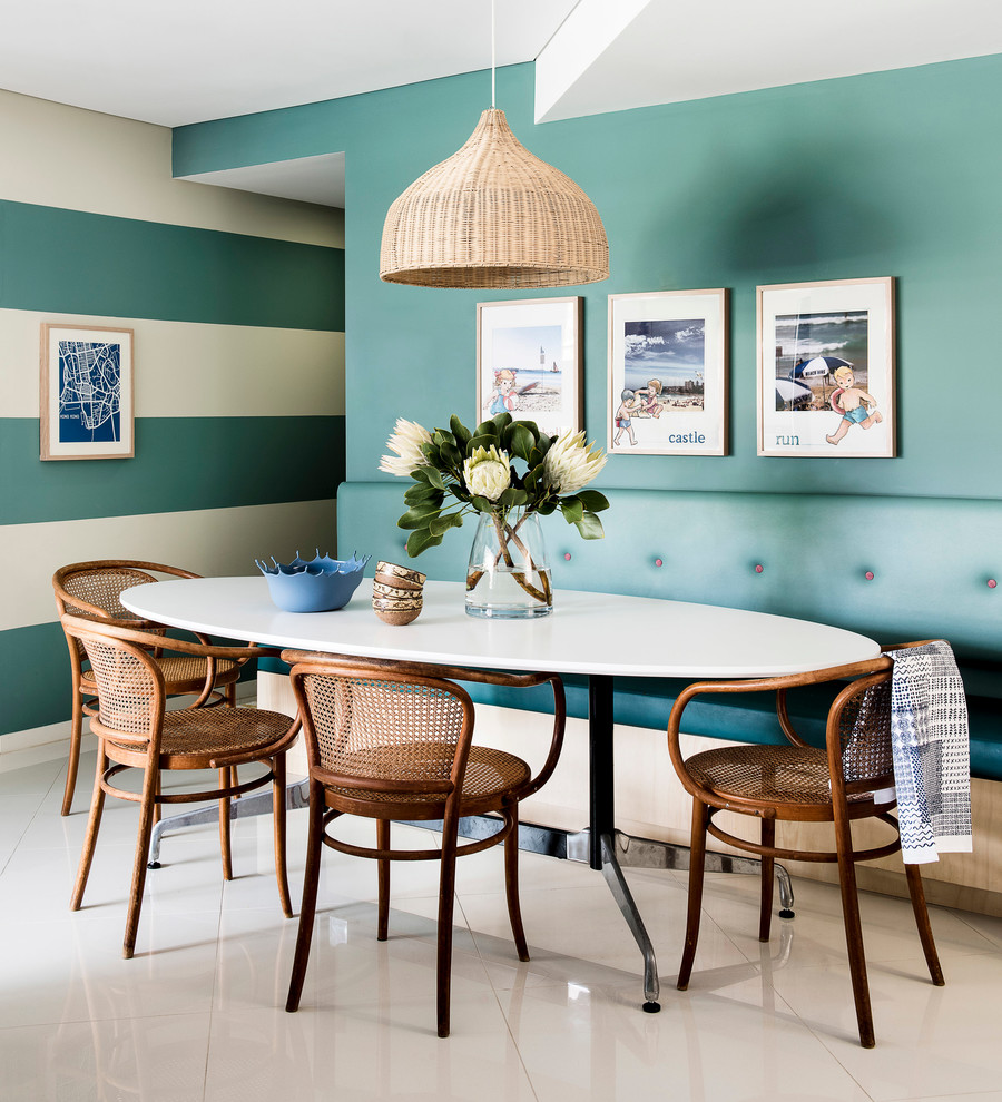 Ejemplo de comedor de cocina marinero con suelo de baldosas de porcelana y paredes azules