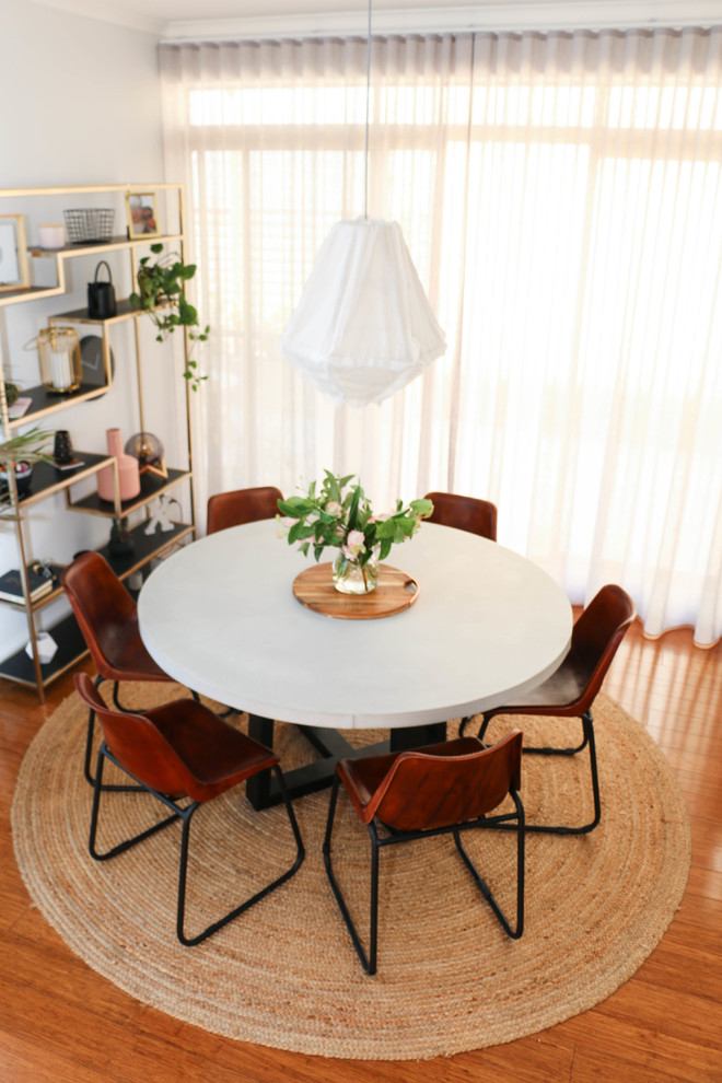 Cette photo montre une petite salle à manger ouverte sur le salon industrielle avec un mur blanc, parquet clair et un sol marron.