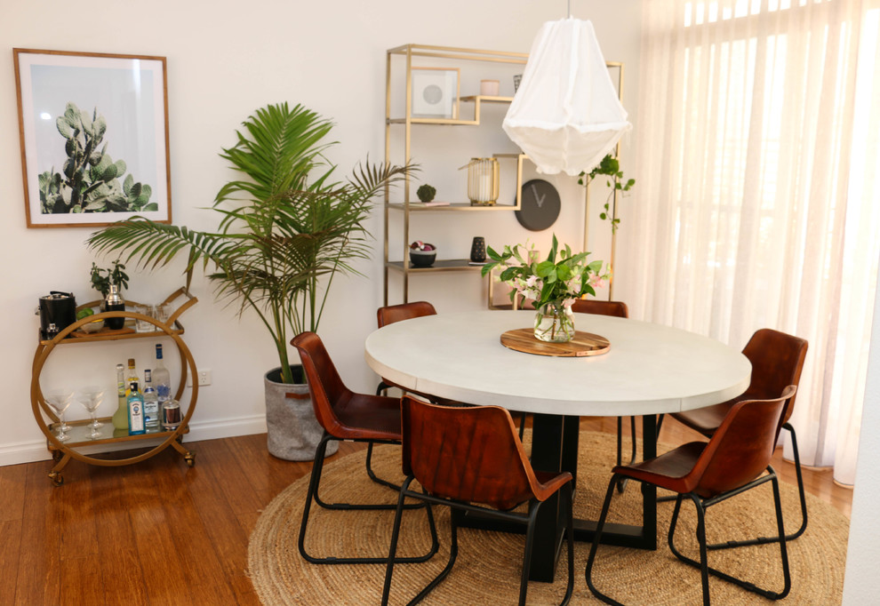 Idée de décoration pour une petite salle à manger ouverte sur le salon urbaine avec un mur blanc, parquet clair et un sol marron.