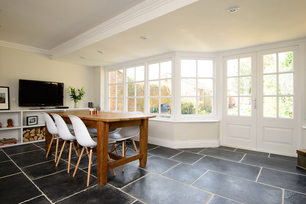 This is an example of a medium sized contemporary kitchen/dining room in Other with white walls and limestone flooring.