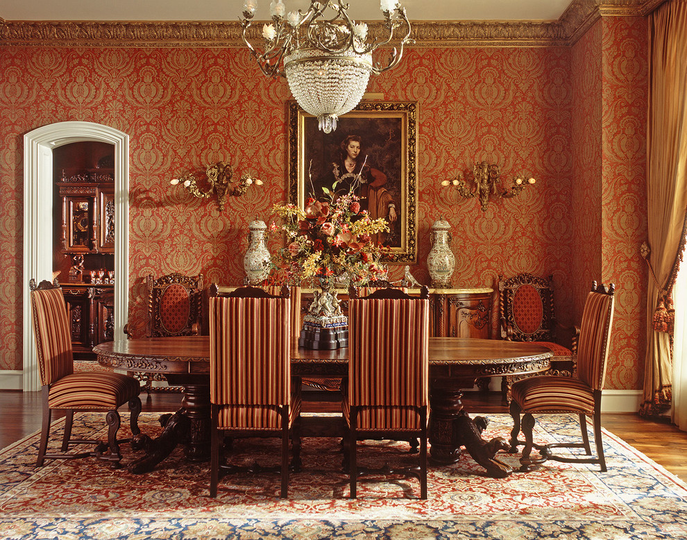 На фото: большая отдельная столовая в классическом стиле с красными стенами, паркетным полом среднего тона и коричневым полом