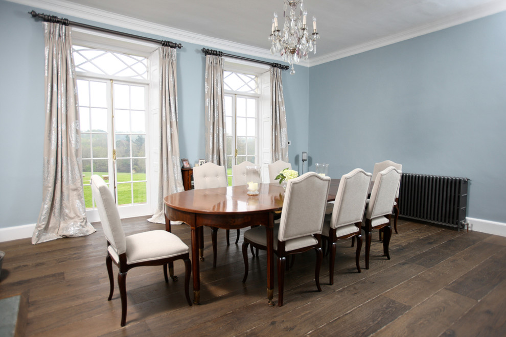 Esempio di una sala da pranzo aperta verso la cucina country con pareti blu, parquet scuro e camino classico