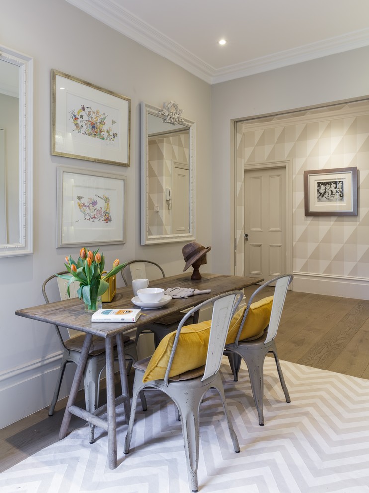 Medium sized traditional open plan dining room in London with grey walls and brown floors.