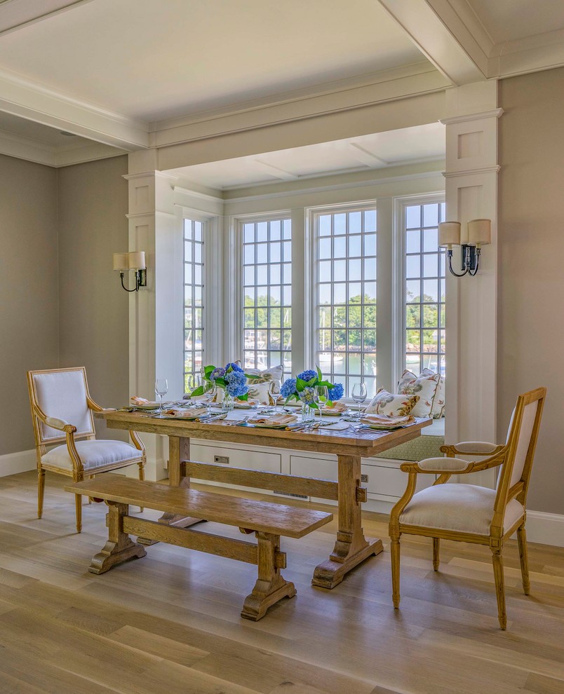 Cette photo montre une petite salle à manger ouverte sur le salon craftsman avec un mur beige et parquet clair.