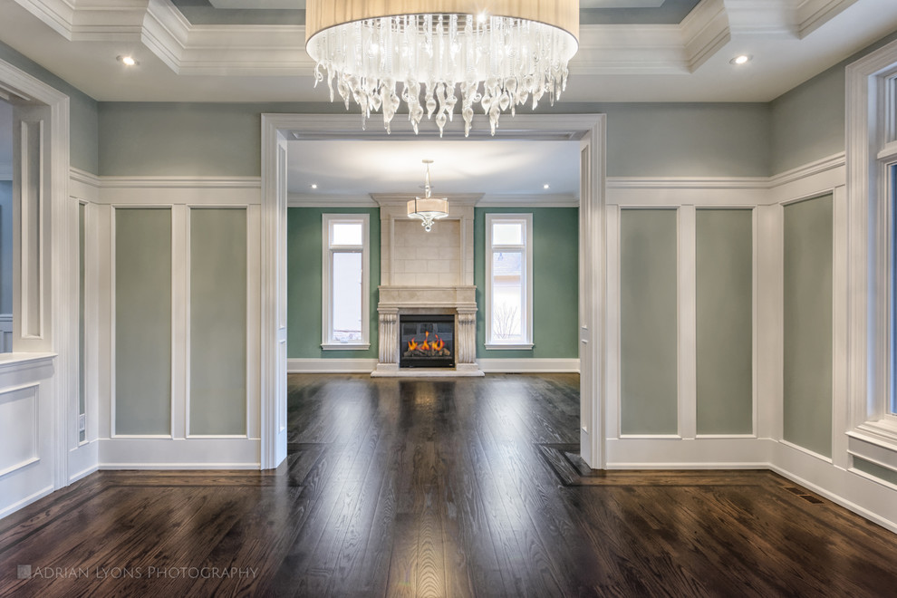 Huge elegant medium tone wood floor enclosed dining room photo in Toronto with gray walls, a standard fireplace and a stone fireplace