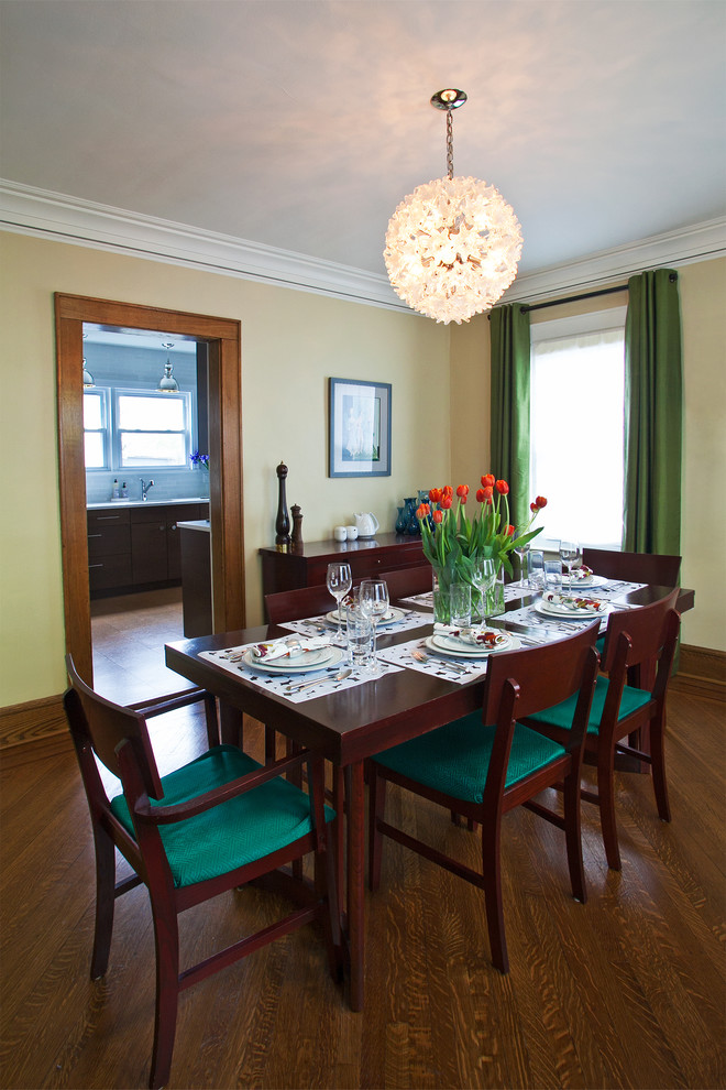 Exemple d'une salle à manger chic avec un mur jaune et un sol en bois brun.