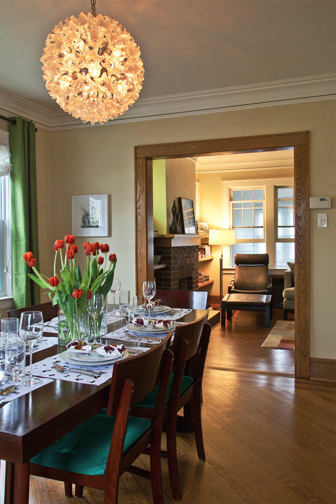 Aménagement d'une salle à manger classique avec un mur jaune et un sol en bois brun.