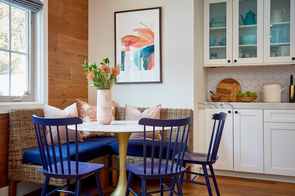 Foto di una sala da pranzo aperta verso la cucina classica con pareti bianche, pavimento in legno massello medio e pavimento marrone