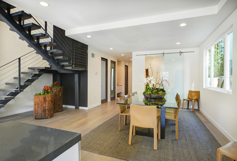 Photo of a contemporary open plan dining room in Los Angeles with beige walls and medium hardwood flooring.