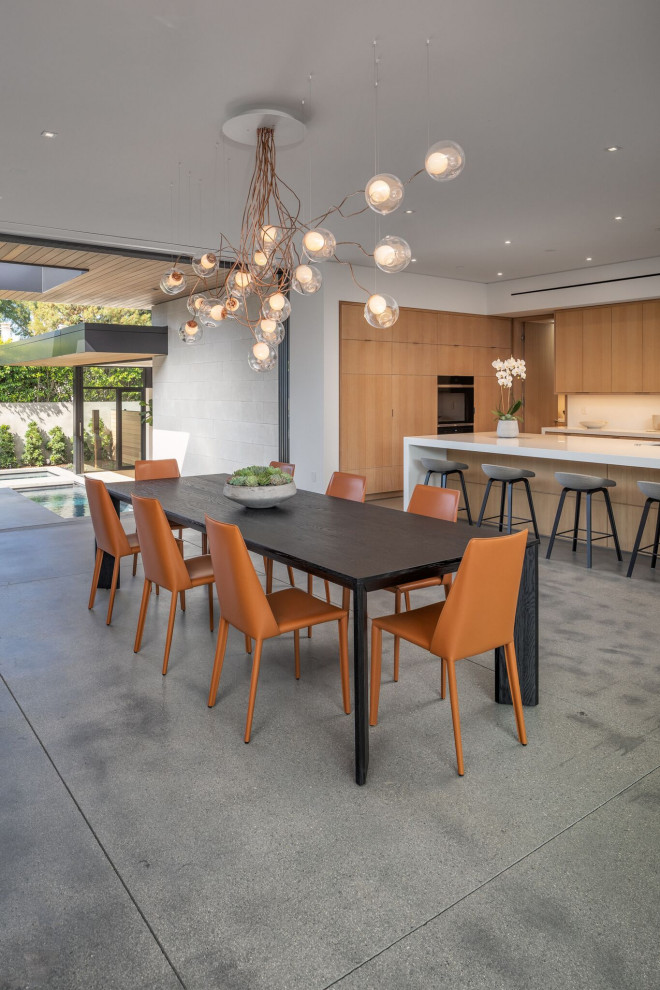 Esempio di una sala da pranzo aperta verso il soggiorno contemporanea con pareti bianche, pavimento in cemento e pavimento grigio