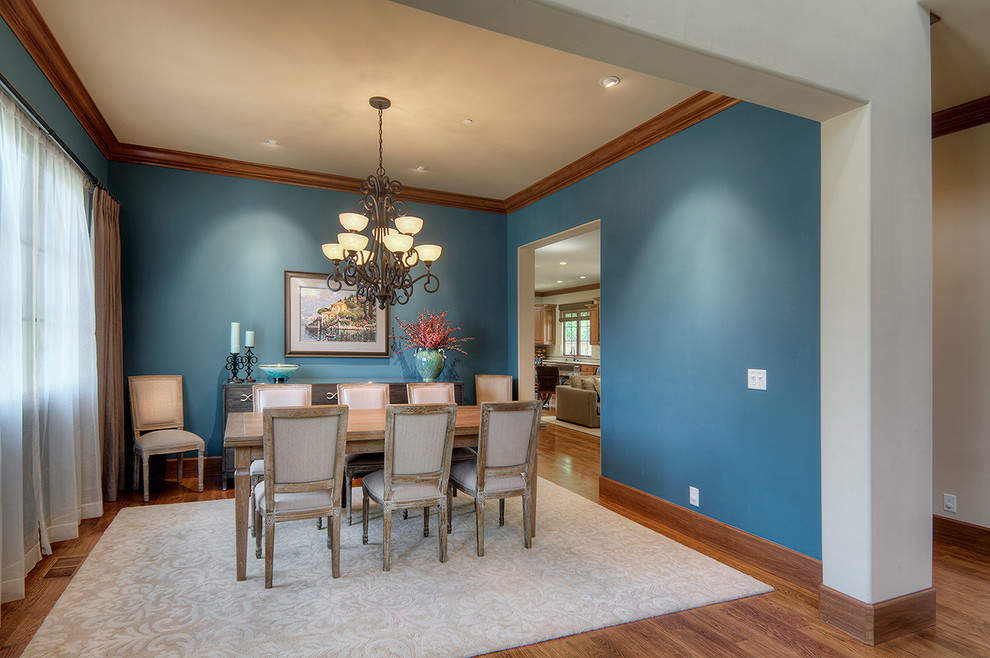 Cette photo montre une salle à manger chic de taille moyenne avec un mur bleu, un sol en bois brun et aucune cheminée.