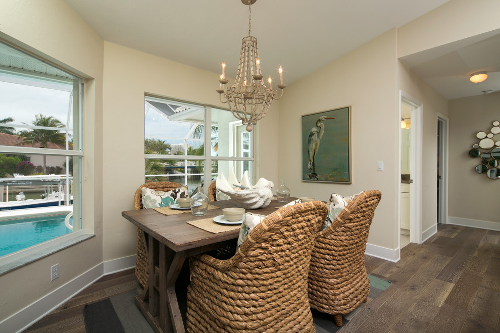 Coastal dining room in Tampa with beige walls and medium hardwood flooring.