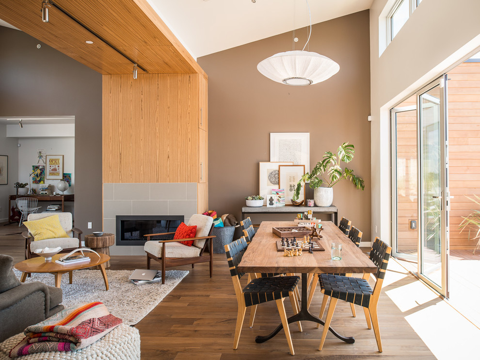 Cette image montre une salle à manger ouverte sur le salon design avec un mur marron et un sol en bois brun.