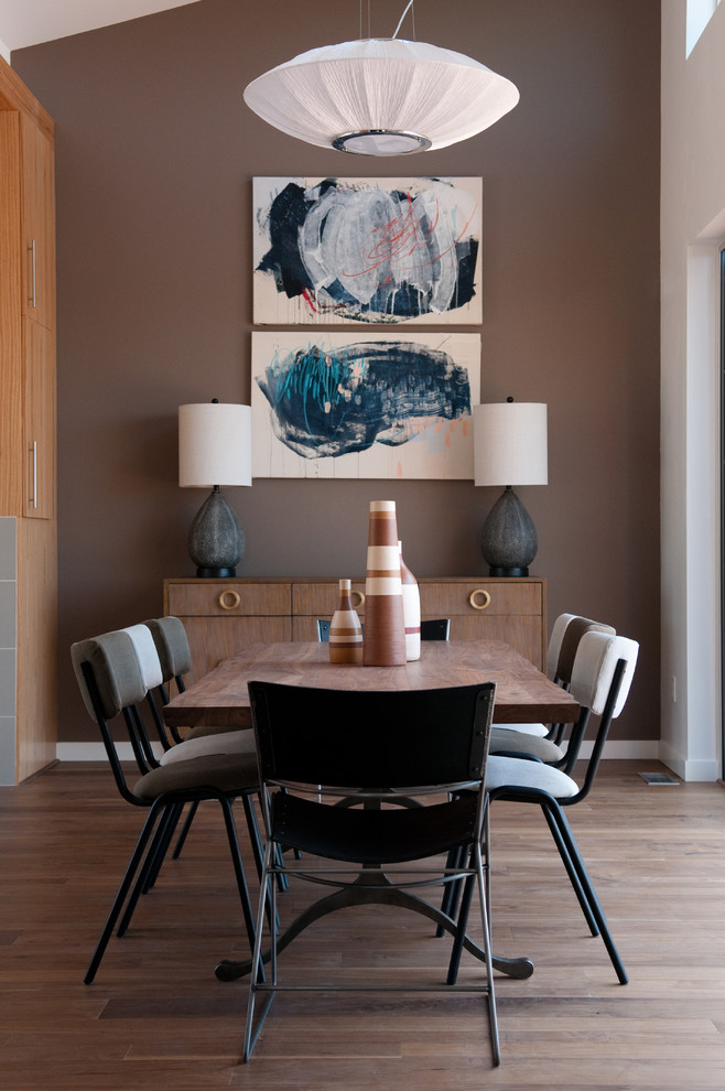 Inspiration pour une petite salle à manger ouverte sur le salon design avec un mur marron, un sol en bois brun, aucune cheminée et éclairage.