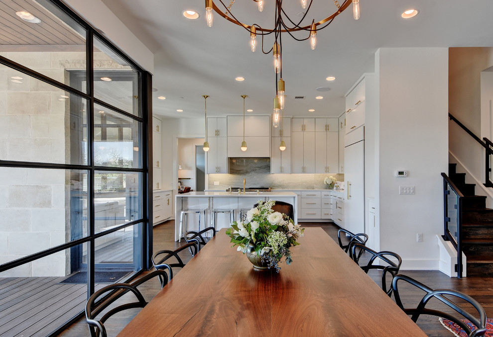 Immagine di una sala da pranzo aperta verso il soggiorno minimal con pavimento in legno massello medio