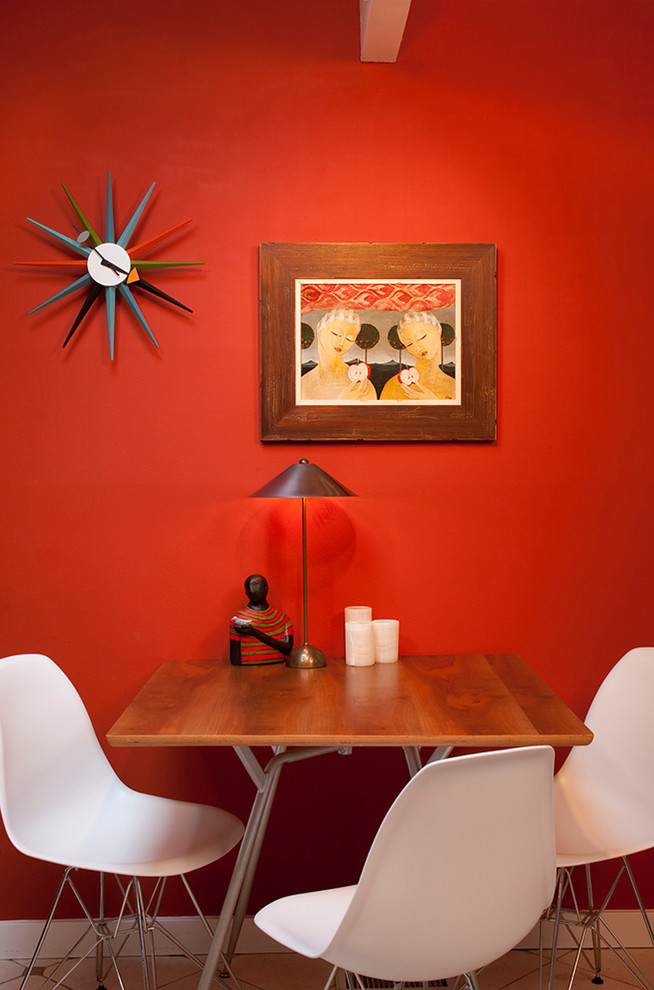 Cette image montre une salle à manger minimaliste avec un mur rouge.