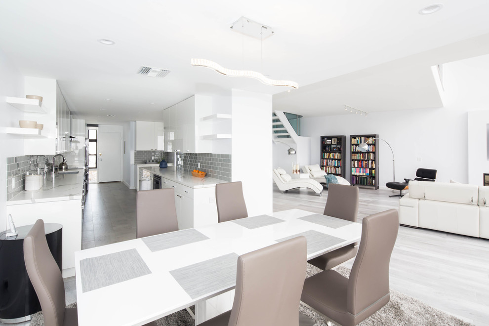 Example of a large trendy porcelain tile and gray floor kitchen/dining room combo design in Los Angeles with white walls