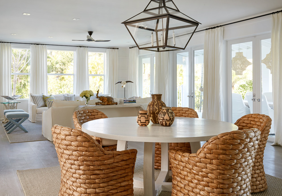 Immagine di una sala da pranzo stile marino con pareti bianche, parquet chiaro e pavimento beige