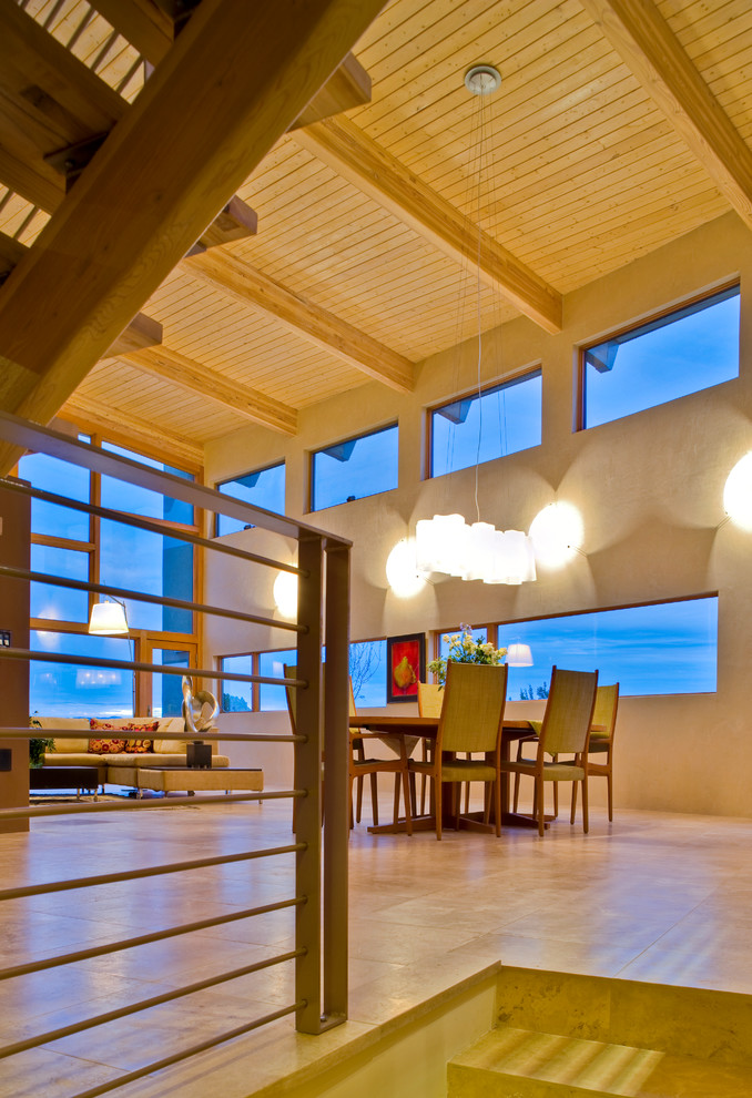 Immagine di un'ampia sala da pranzo aperta verso il soggiorno minimalista con pareti beige e pavimento in travertino