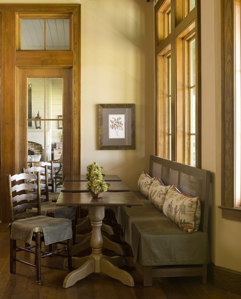 This is an example of a country dining room in Atlanta with beige walls and dark hardwood flooring.