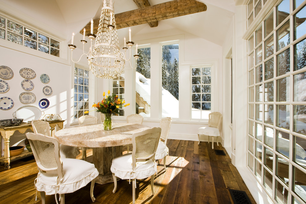 Cette photo montre une salle à manger ouverte sur le salon montagne de taille moyenne avec un mur blanc, parquet foncé, aucune cheminée et un sol marron.