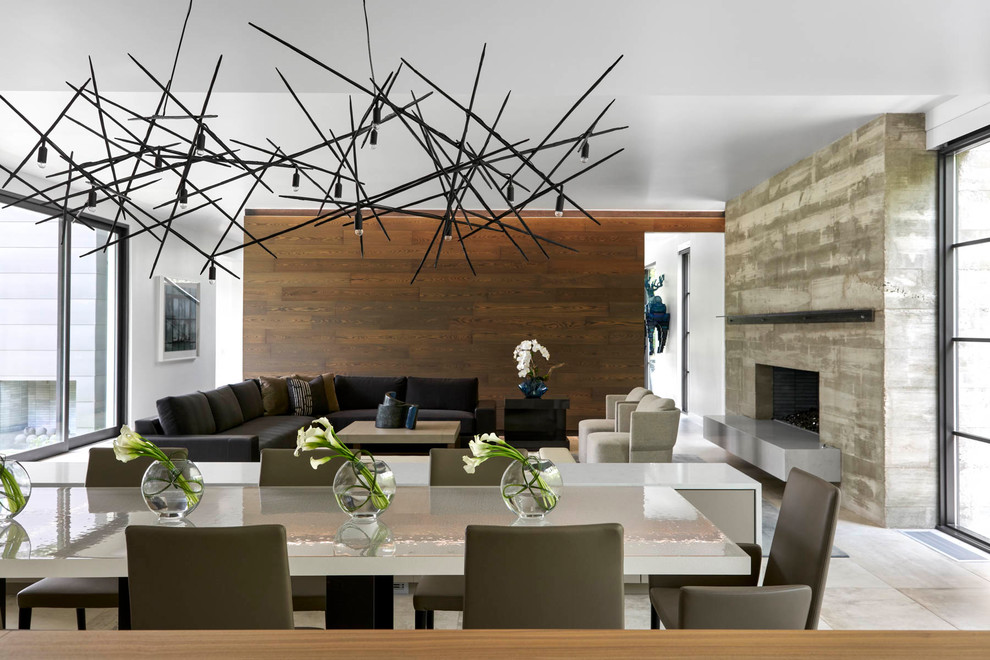 Idée de décoration pour une salle à manger ouverte sur le salon design de taille moyenne avec un mur blanc, sol en béton ciré, une cheminée standard, un manteau de cheminée en béton et un sol gris.
