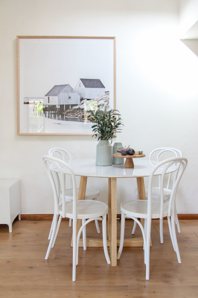Foto di una sala da pranzo design con pareti bianche e parquet chiaro